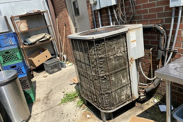 Fouled walk-in condenser coil behind a restaurant